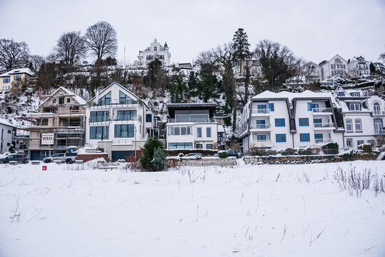Elegant hillside homes covered in snow during rare winter weather along the Elbe River