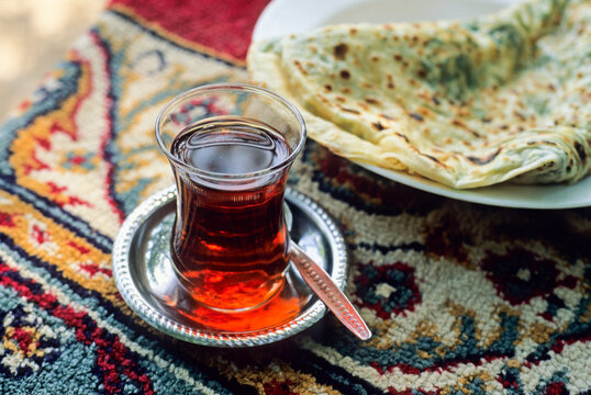 Enjoying tea with a plate of traditional bread in a cozy setting during the day