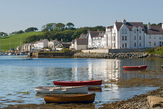 Colorful boats bob in the water near the shore in Portaferry during a clear day