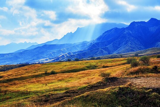 Sun-rays penetrate clouds and illuminate hills during autumn in Aso, Kumamoto Prefecture, Kyushu, Japan