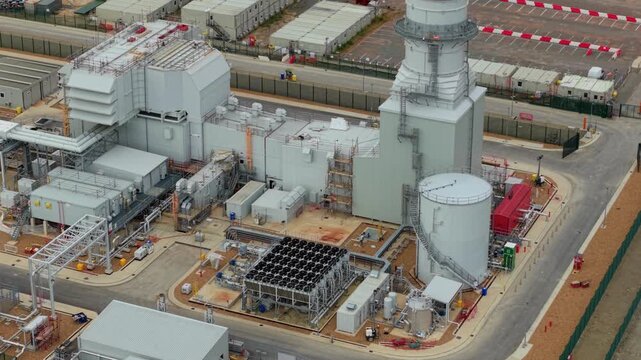 Aerial wide shot of gas turbine peaking power station and electrical substation in rural Bedfordshire UK