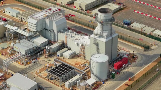 Aerial wide shot of gas turbine peaking power station and electrical substation in rural Bedfordshire UK
