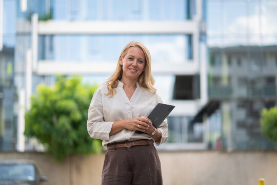 Businesswoman holding tablet smiling in city environment