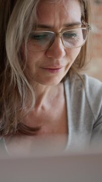 Woman In Glasses Working Remotely On Laptop From Home Vertical Video