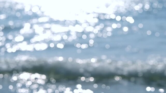 Sea. Sea waves. Abstract view of blue sea with white ripples on water and white sun glare on sunny summer day. Nature backdrop. Natural background. Blurred bokeh background.