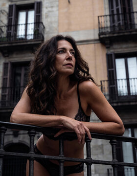 Sinnlicher Moment: Nachdenkliche Frau auf einem historischen Balkon in Barcelona