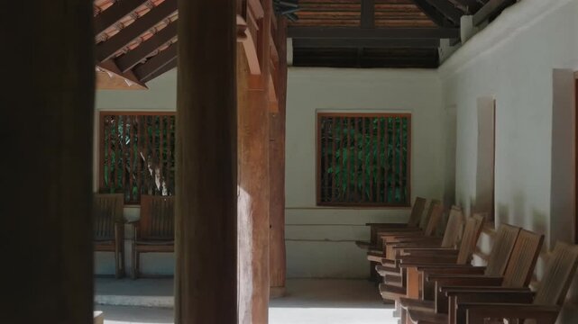 Traditional wooden corridor with chairs inside Wat Phra Lat temple, Peaceful temple interior with timber columns and veranda, Chiang Mai, Thailand 4k
