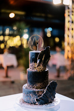 Elegant Three Tier Black Wedding Cake with Decorative Accents