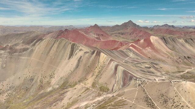 Aerial view of Vinicunca, also known as Rainbow Mountain, showcasing its vibrant mineral-rich striped slopes and rugged Andean terrain in Quispicanchi Province, Cusco, Peru.
