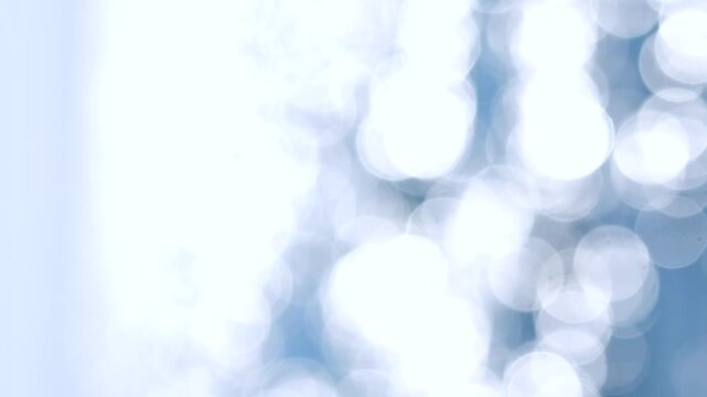 Sea waves, horizon line, blue sky. Abstract view of blue sea with white ripples on water and white sun glare on sunny summer day. Nature backdrop. Natural background. Blurred bokeh background Vertical