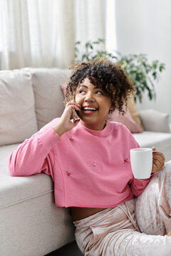 Smiling young woman enjoys a cozy afternoon chat at home with a cup in hand