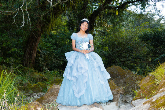Retrato de Quincea&ntilde;era Feliz con Corona y Ramo de Flores en la Naturaleza.Alegre Quincea&ntilde;era con Corona y Ramo de Flores en un Escenario Natural