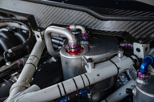 Precision engineered dry sump oil tank and AN hose assembly mounted within a high performance competition vehicle structural engine bay