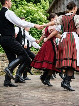 Traditional European Folk Dancers in Authentic Costumes Performing a Circle Dance Outdoors