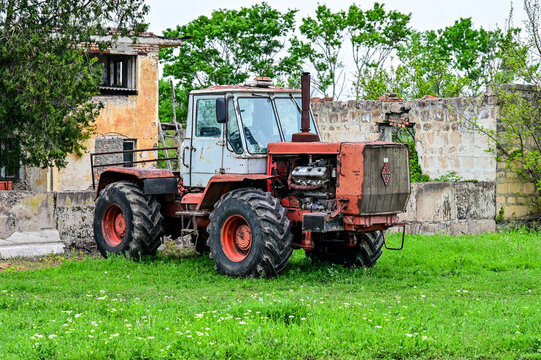 Soviet T-150K vintage tractor in front of dilapidated buildings in Sighnaghi, historic agricultural tractor, farm machinery, Kakheti, Sighnaghi, Georgia 10.04.25
