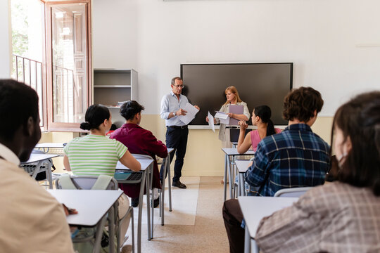 Teachers interacting with students in modern classroom setting