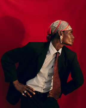 Editorial portrait of Black model against red backdrop.