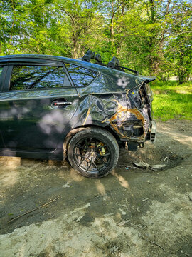 A damaged Toyota Prius hybrid car with a large dent in the fender and a missing bumper is parked in the woods near Tbilisi; accident damage and body damage to the car, Georgia 10.04.2025