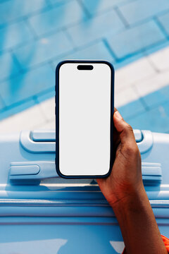 Travel smartphone mockup with white screen over blue suitcase
