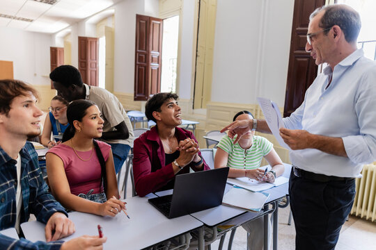 Teacher engaging diverse students in university classroom discussion