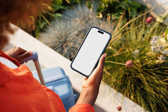 Smartphone mockup with white screen by travel suitcase