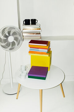 View in office in summer: ventilator, table, books and coffee cup