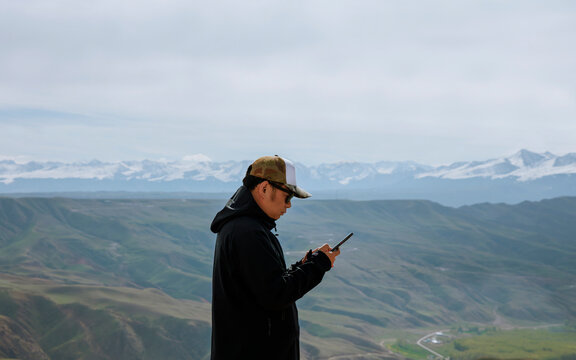 A traveler using a mobile phone on a plateau.