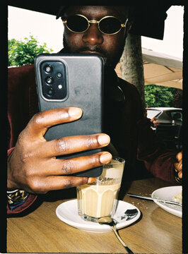 Person taking selfie with smartphone in cafe