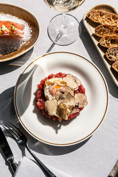 Overhead view of gourmet red tuna tartare with a fried egg and black t