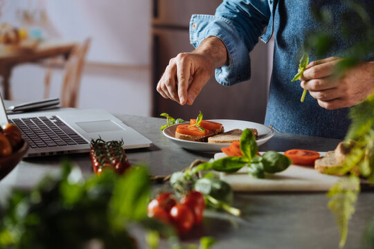 Man preparing healthy meal following an online recipe