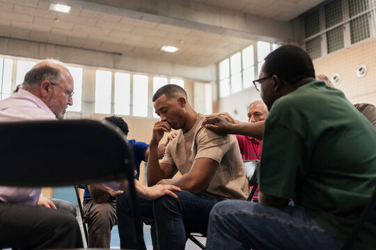 Diverse men offering comfort during group therapy session