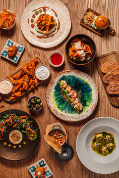 Wooden table filled with an assortment of gourmet Spanish tapas
