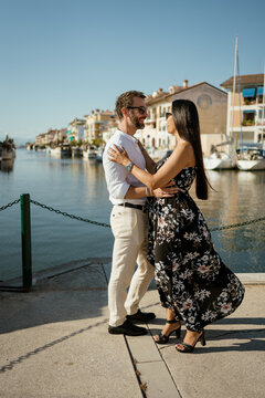 A couple embracing by the town harbour during vacation