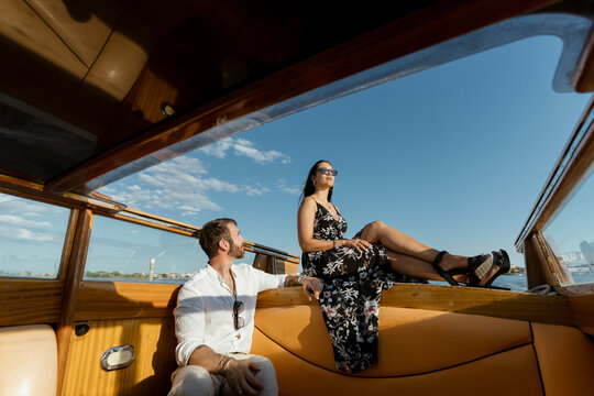 A romantic couple on a luxury speedboat at sunset