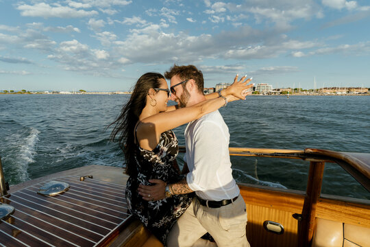 Romantic Couple embracing on Scenic Boat Tour at sunset