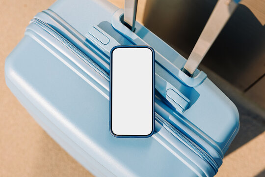 Travel smartphone mockup with white screen on blue suitcase