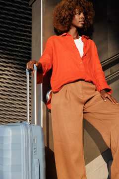 Woman traveling with blue suitcase on stairway