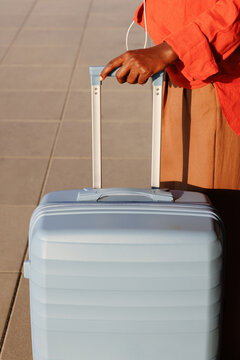 Travel suitcase pulled by hand across tiled floor
