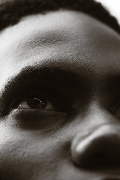 Close-up black and white portrait of young Black man's eye.