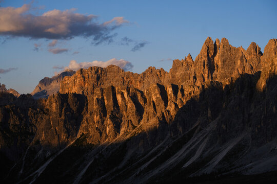 Golden sunset light on Dolomite cliffs in Passo Giau