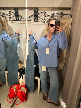 Woman Trying on Jeans in Store Fitting Room Mirror Selfie
