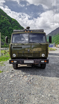 Green KamAZ-5320 truck with trailer and Russian license plates on a gravel road in the mountainous region near Vladikavkaz, historic Soviet truck, North Ossetia-Alania, Russia 11.05.25