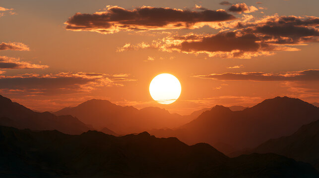 Stunning sunset over majestic mountains, casting a warm glow with vibrant orange hues.