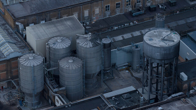 Aerial view of industrial storage tanks and silos at a manufacturing facility in Sittingbourne, England, United Kingdom.