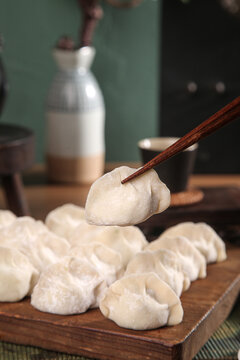 Traditional Handmade Asian Seafood Dumplings with Chopsticks on Wooden Board