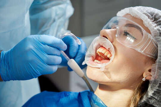 Dentist using a saliva ejector during a dental examination