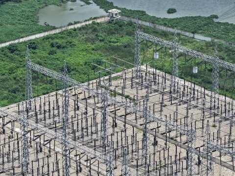 Aerial view of Aminbazar 400230132 kV Grid Substation with steel lattice towers, electrical equipment, and surrounding green vegetation in Aminbazar, Dhaka Division, Bangladesh.