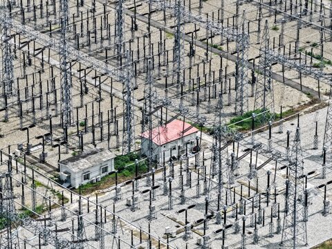 Aerial view of the Aminbazar 400230132 kV Grid Substation featuring metal lattice towers, electrical equipment, and utility buildings in Aminbazar, Dhaka Division, Bangladesh.