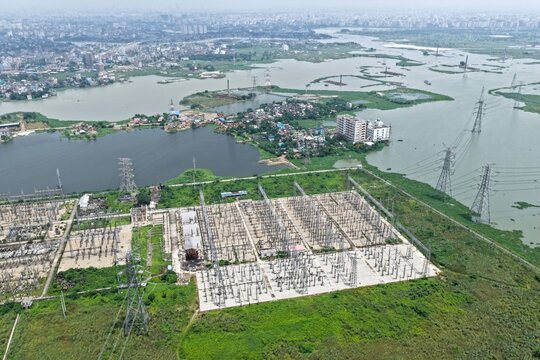 Aerial view of Aminbazar 400230132 kV Grid Substation, featuring electrical infrastructure and transmission towers near wetlands in Aminbazar, Dhaka Division, Bangladesh.