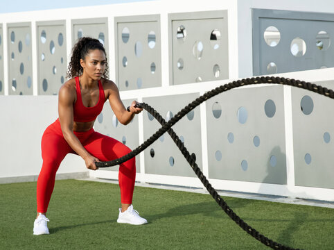 young woman training with ropes.